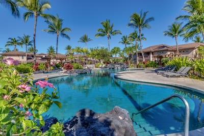 The pool’s shimmering surface reflects the Hawaiian sky, inviting you to swim and unwind. Colony Villas offers a serene setting for relaxation and fun.