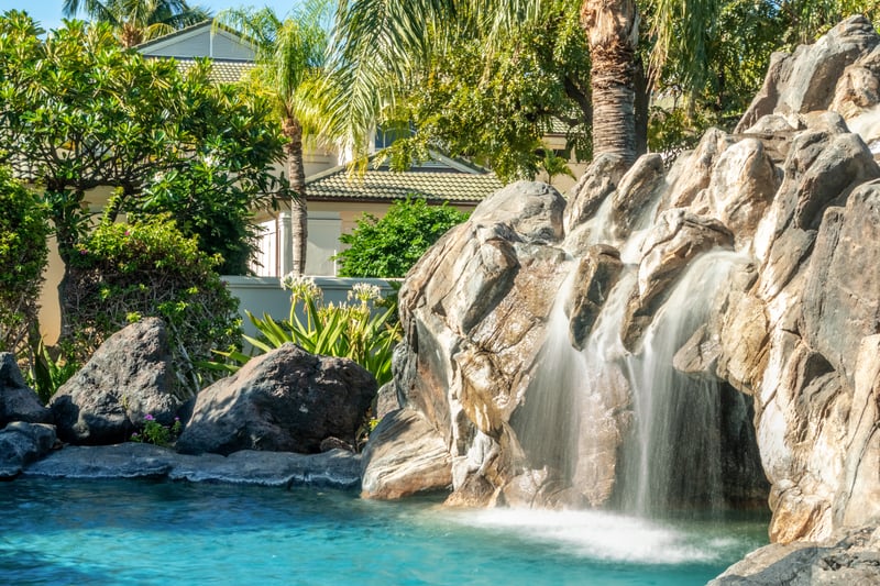 The pool features a stunning rock waterfall