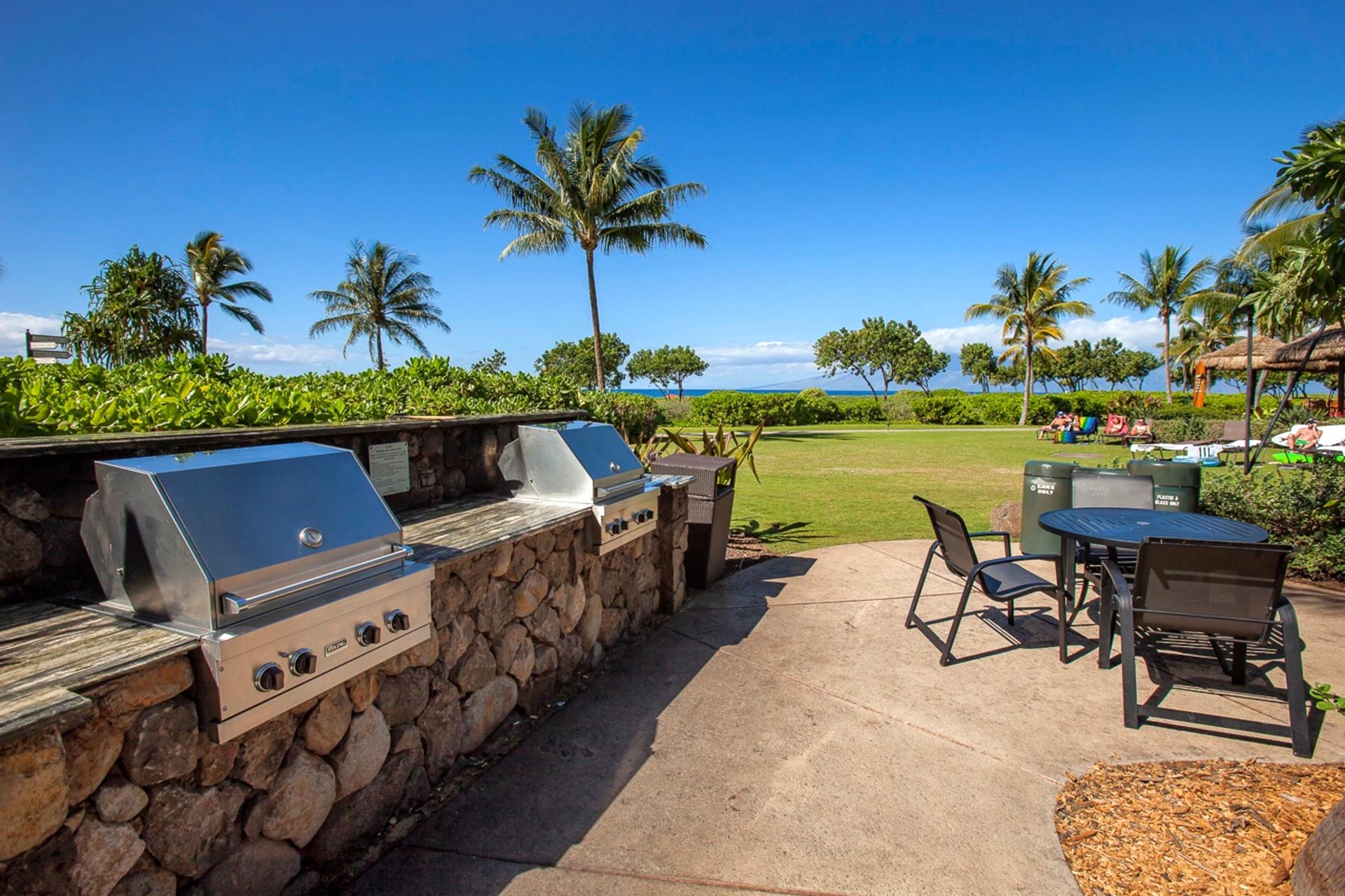 Ocean-view BBQ area at Honua Kai with premium grills and shaded seating, perfect for casual outdoor meals just steps from the sand.