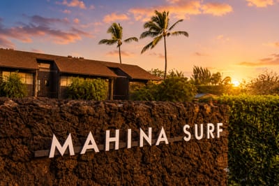 Mahina Surf entrance sign at sunset — the property's lava-rock monument welcomes guests to this oceanfront Lahaina condominium community