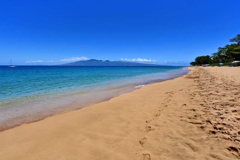 Walk barefoot on golden sands with panoramic ocean views, distant islands & crystal-clear turquoise water
