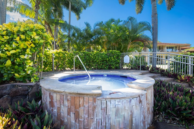 Private resort jacuzzi surrounded by lush tropical gardens, elegant stone design & open-air relaxation