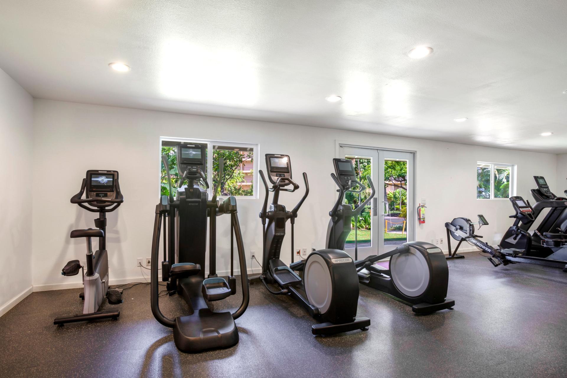 Private resort fitness center with cardio, strength training & bright natural light for energized island workouts