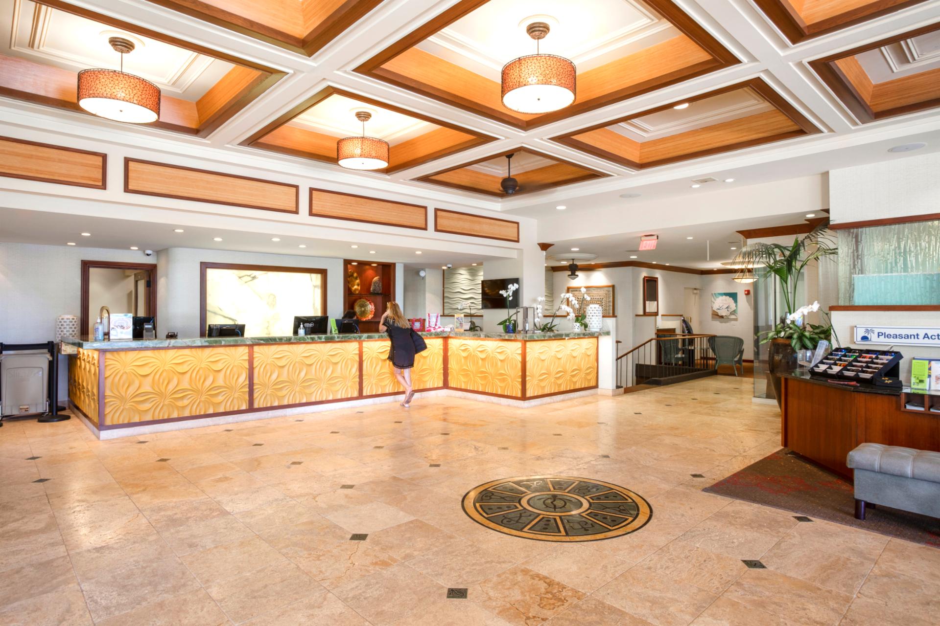 Elegant resort lobby with warm island-inspired design, high ceilings & welcoming front desk for effortless check-in