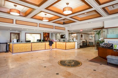 Elegant resort lobby with warm island-inspired design, high ceilings & welcoming front desk for effortless check-in