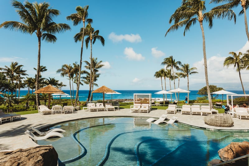 Lounge at our oceanfront serenity pool, with in-water loungers, private cabanas & sweeping Kapalua Bay views