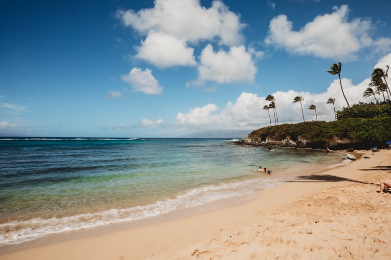 Relax on Maui’s secluded beach with soft golden sand, turquoise waters & swaying palms in pure tropical serenity