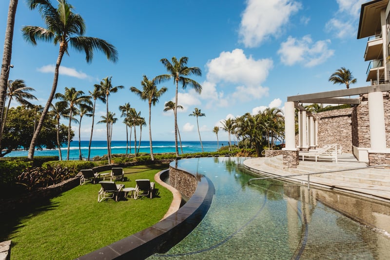 Stroll along our tranquil lagoon pool with infinity-edge views, lush palms & serene beachfront beauty