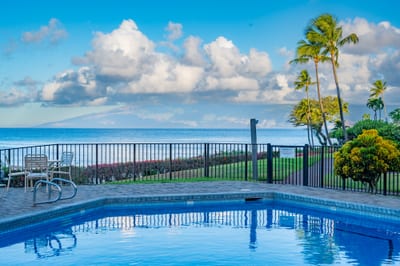 Soak in panoramic ocean views from the pool deck at Napili Point, where swaying palms and calm waters create a peaceful, picture-perfect escape.