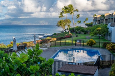 Peaceful ocean-view pool at Napili Point with loungers and umbrellas, set above the rocky shoreline for quiet swims and postcard-worthy sunset views.
