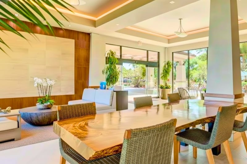 Spacious open-air lobby with modern tropical design, natural light, elegant seating, and lush resort garden surroundings