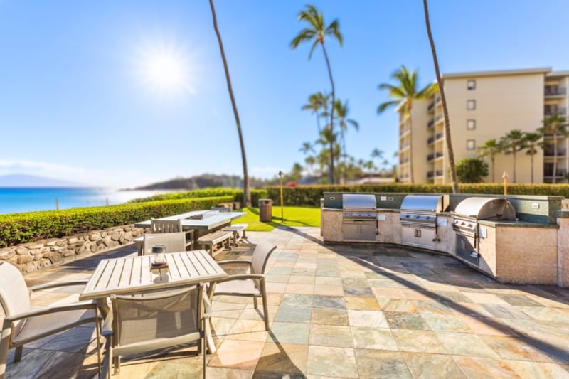 Beachfront BBQ pavilion with panoramic ocean views, outdoor dining, tropical landscaping, seating & relaxed island atmosphere