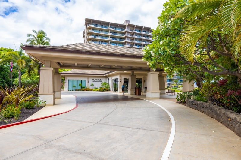 Private resort entrance with lush tropical landscaping, exclusive arrival drive, elegant design, and luxury beachfront access