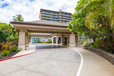 Private resort entrance with lush tropical landscaping, exclusive arrival drive, elegant design, and luxury beachfront access