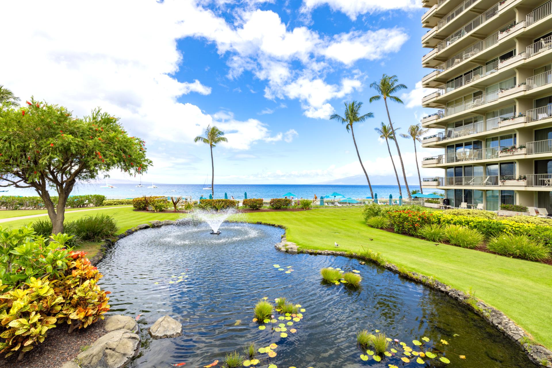 Oceanfront resort with koi pond, water fountains, lush tropical gardens, palm trees, ocean views & vibrant island landscaping