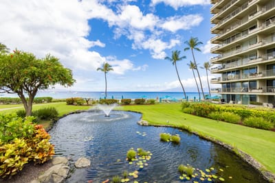 Oceanfront resort with koi pond, water fountains, lush tropical gardens, palm trees, ocean views & vibrant island landscaping