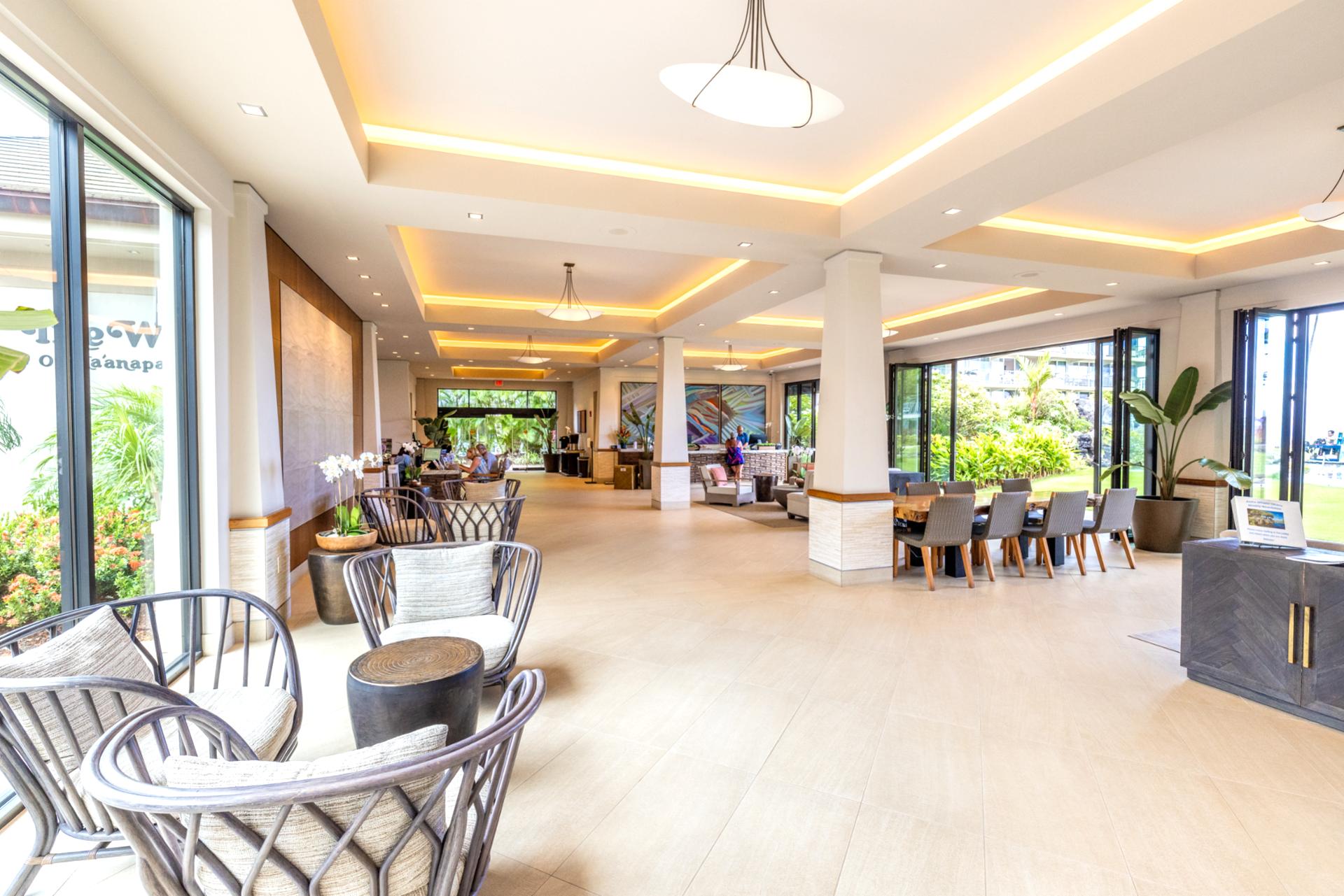 Spacious open-air lobby with modern tropical design, natural light, elegant seating, and lush resort garden surroundings