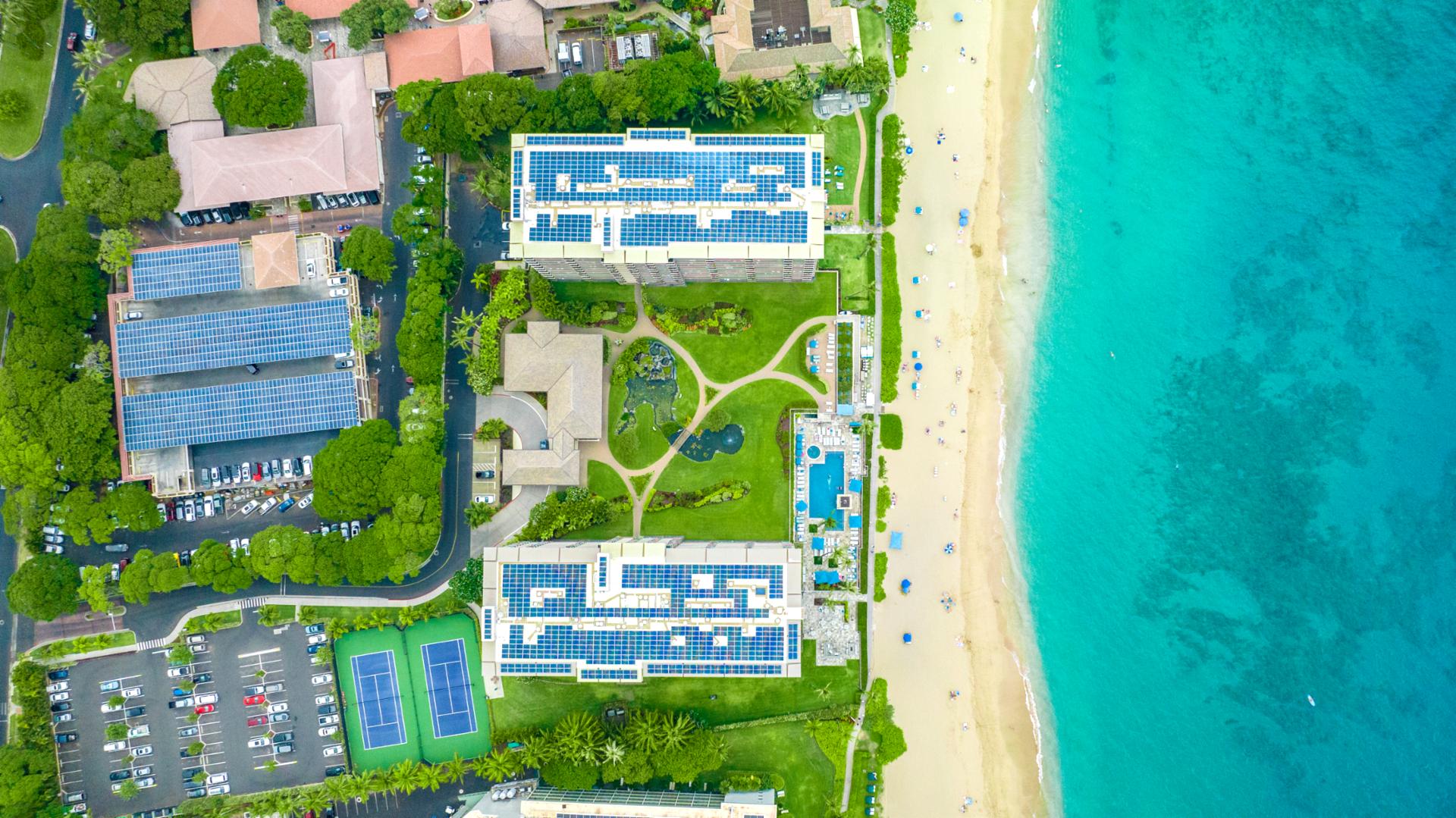 Aerial view of Maui beachfront resort with oceanfront condos, turquoise waters, and white sand beach