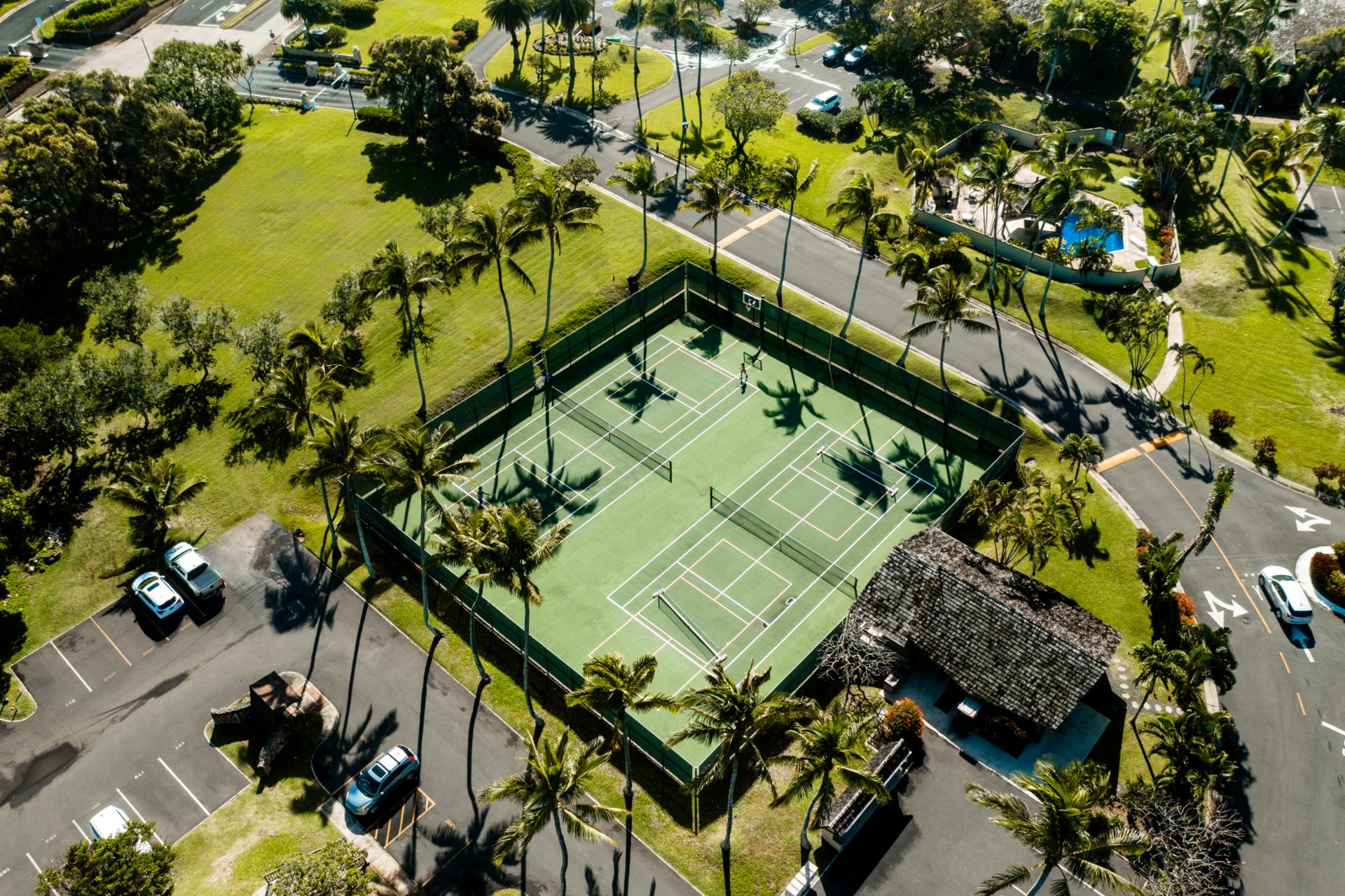 Tennis courts at Kuilima Estates sit beneath swaying palms and island sun, perfect for a friendly match before heading to the beach or pool.