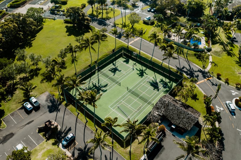 Tennis courts at Kuilima Estates sit beneath swaying palms and island sun, perfect for a friendly match before heading to the beach or pool.