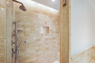 This shower whispers “serenity now” with stone walls so warm, even your shampoo bottle might start to meditate