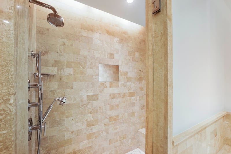 This shower whispers “serenity now” with stone walls so warm, even your shampoo bottle might start to meditate
