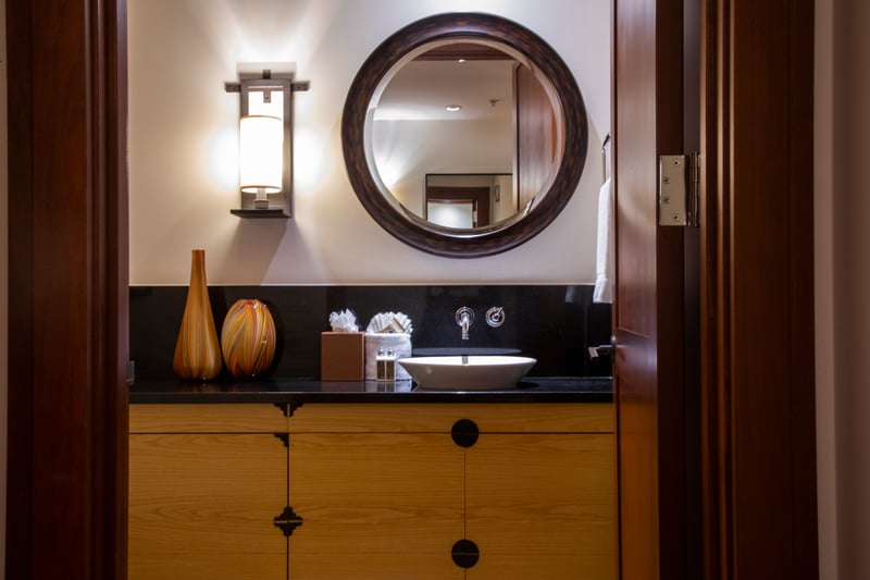 This guest bathroom blends warm wood tones, elegant lighting, and sleek finishes to offer a spa-like experience