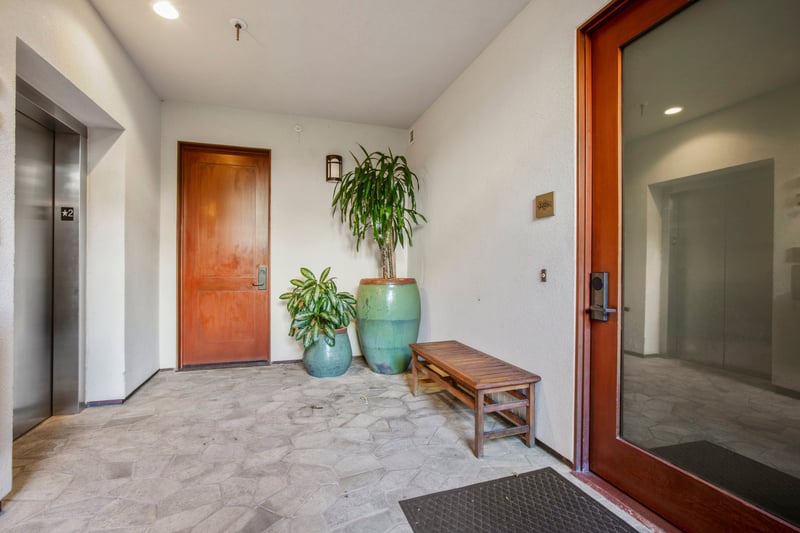 Your adventure begins at this cheerful doorway—where polished wood, plants, and soft light whisper 'welcome home.' MON-2204