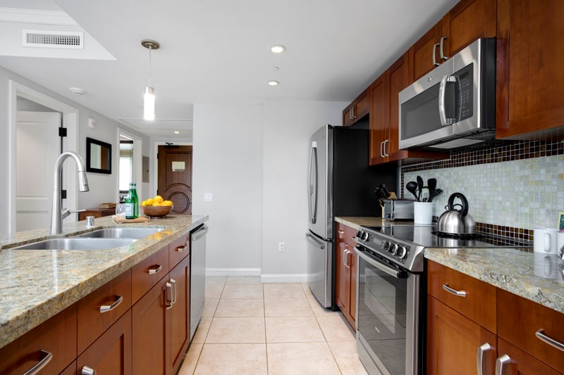 Spacious kitchen with granite countertops and sleek stainless steel appliances. HKK-220