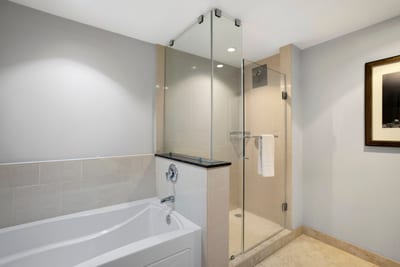Sleek modern bathroom featuring glass shower and deep soaking tub. HKK-220