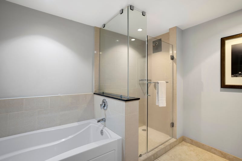 Sleek modern bathroom featuring glass shower and deep soaking tub. HKK-220