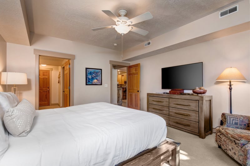 Your tranquil primary bedroom offers plush bedding, warm lighting, and direct access to the ensuite bath.