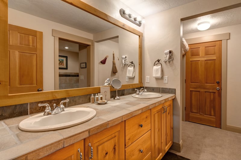 Refresh in your ensuite with a wide granite vanity, warm-toned finishes, and ample lighting to start your day.