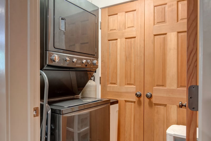 Your in-unit laundry nook includes a stacked washer and dryer with built-in wood cabinetry for convenient storage.