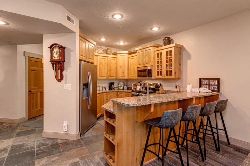 Your fully equipped kitchen includes granite counters, bar seating for four, and custom wood cabinetry with lodge-inspired details.
