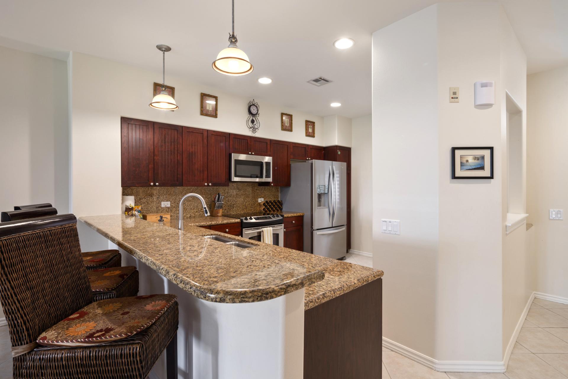 Fully equipped kitchen includes full-size appliances and bar seating for social cooking.