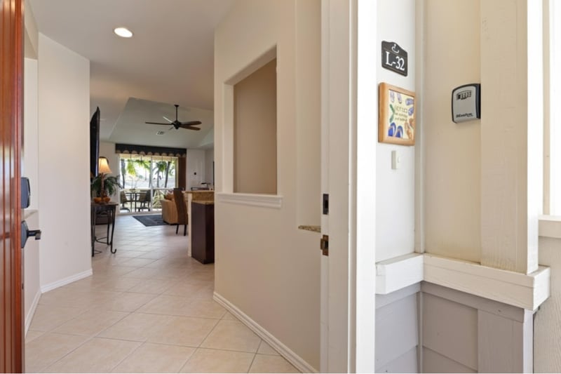 Entry hallway connects the bedrooms and main living space with warm lighting and tile floors.