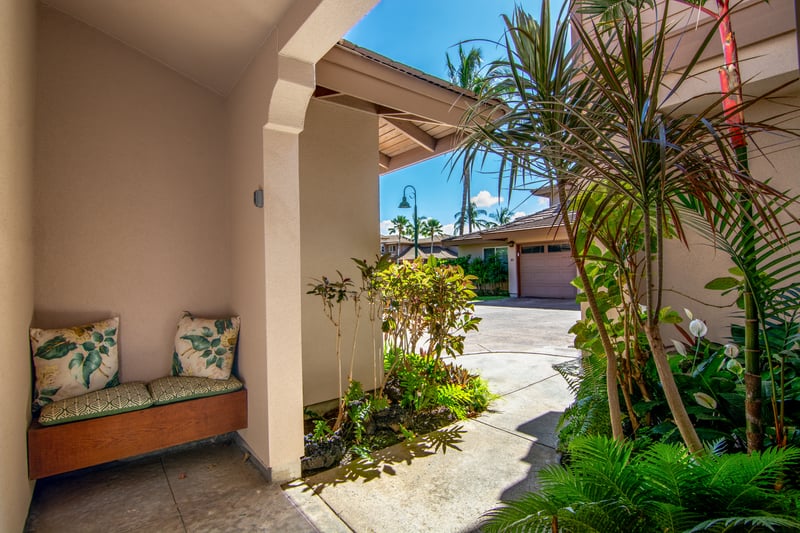 Covered entry framed by lush greenery and tropical flowers WCV-305