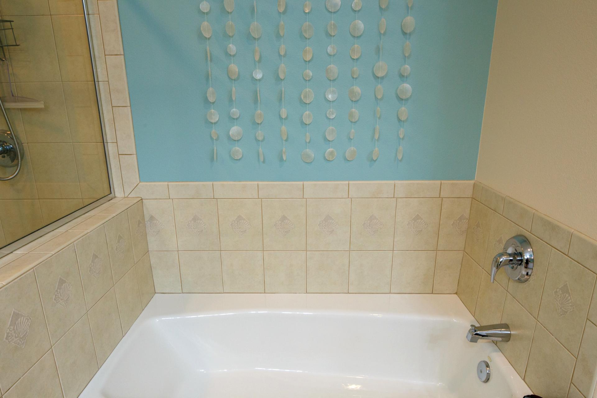 Deep soaking tub surrounded by warm tile and soft natural light
