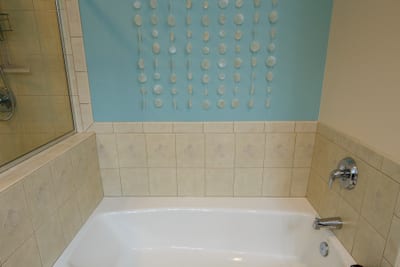 Deep soaking tub surrounded by warm tile and soft natural light