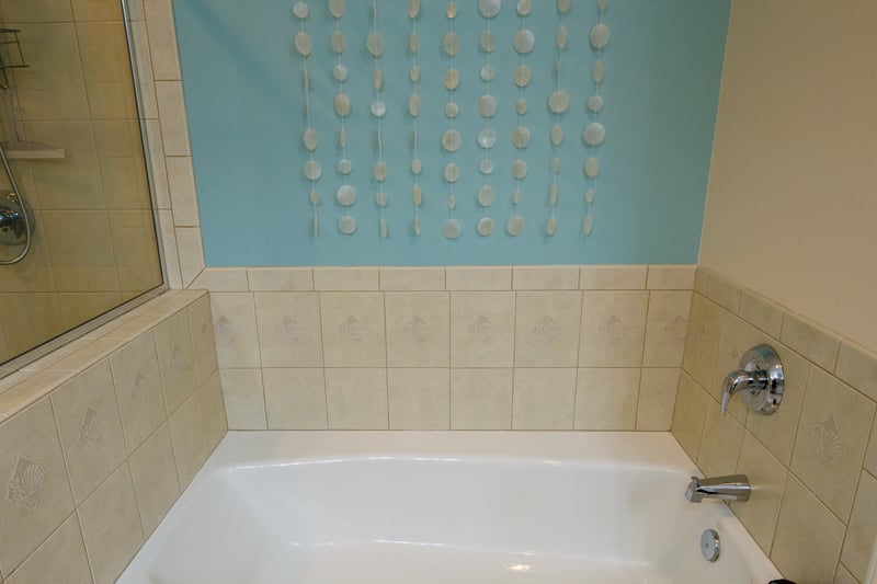 Deep soaking tub surrounded by warm tile and soft natural light WCV-305
