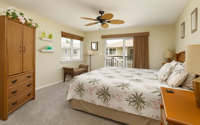 Elegant bedroom with ceiling fan, floral bedding, and calming neutral tones