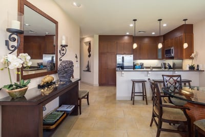 Sleek kitchen with rich wood cabinetry, pendant lighting, and stainless steel appliances HLI-12A