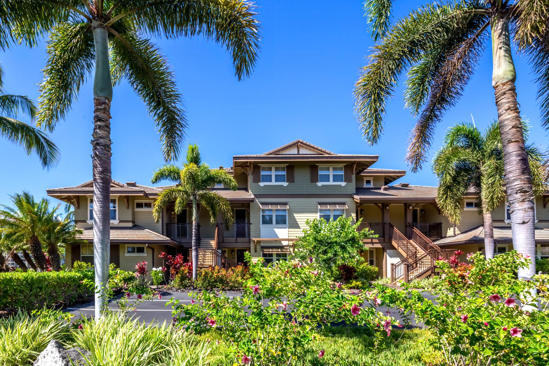 Tropical paradise condo surrounded by palm trees and vibrant flowers.