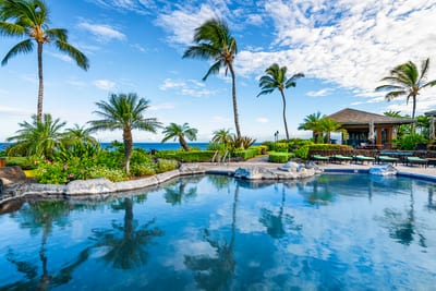 Lounge poolside with serene views and lush greenery, just steps from your unit.