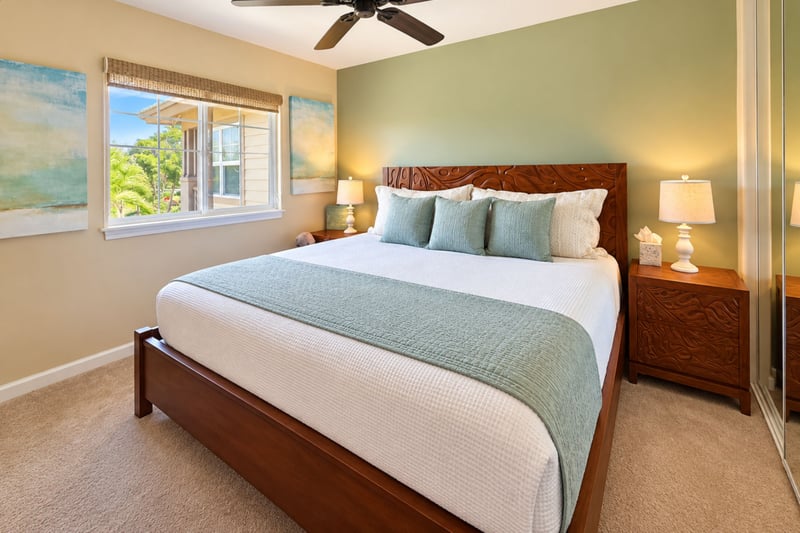 Guest bedroom with a king bed, carved wood headboard, matching nightstands, and a mirrored closet.