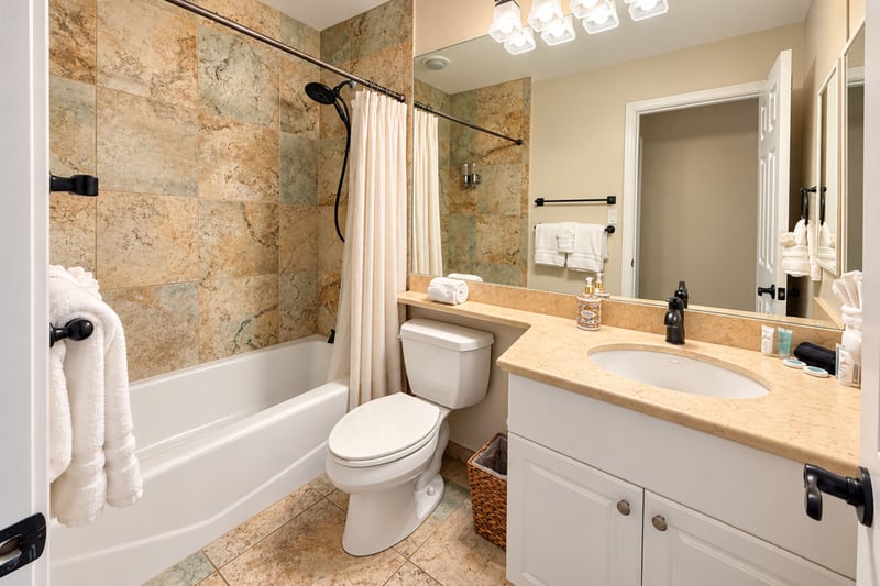 Guest bathroom with a shower and tub combination, a single vanity, and fresh white towels.