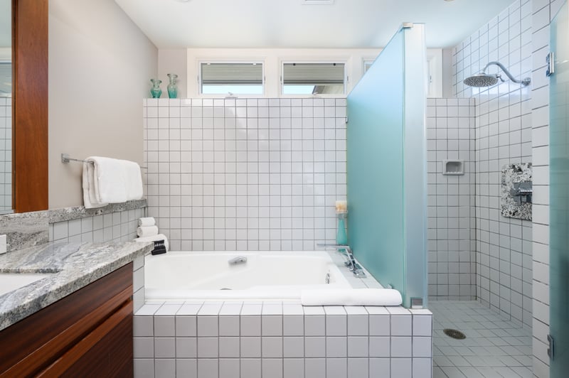 A soaking tub is a welcome addition in this bright, airy bathroom, stocked with essentials for your comfort and convenience.