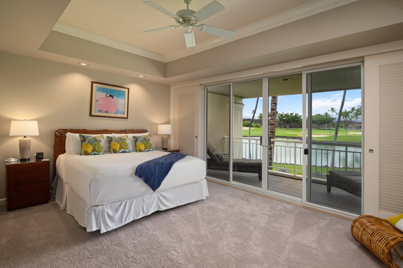 Luxurious primary suite featuring a plush king bed and direct lanai access.