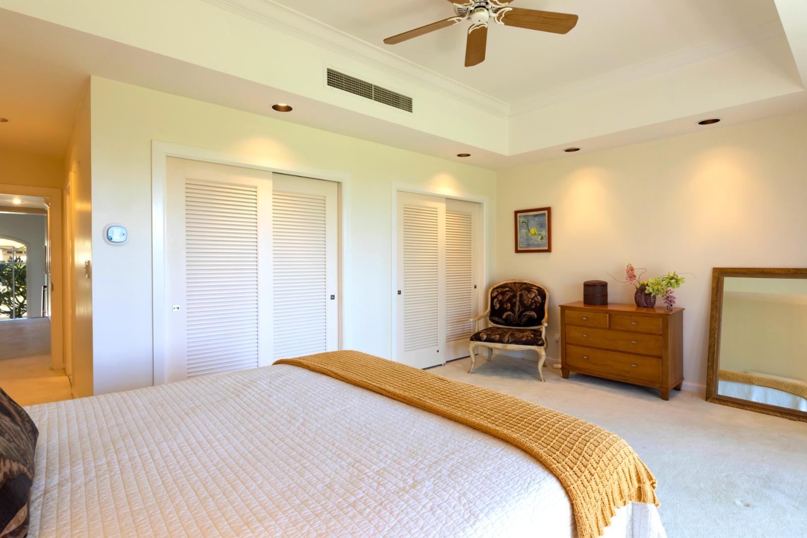 Dream easy in this elegant island bedroom with soft linens, fresh air, and calming green tones